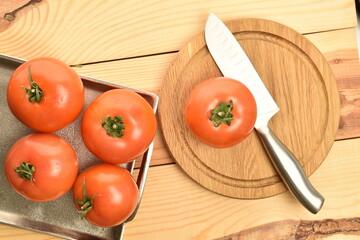 Fresh ripe, juicy, organic tomato, close-up, on a wooden table.