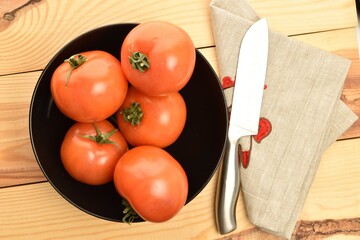 Fresh ripe, juicy, organic tomato, close-up, on a wooden table.