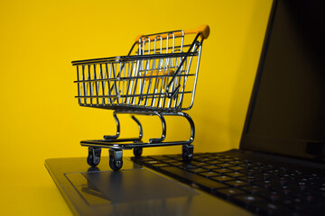 E-Commerce. Online shopping, shopping cart on laptop keyboard.