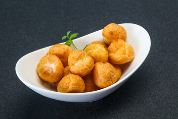 Sweet tasty profiteroles heap in the bowl