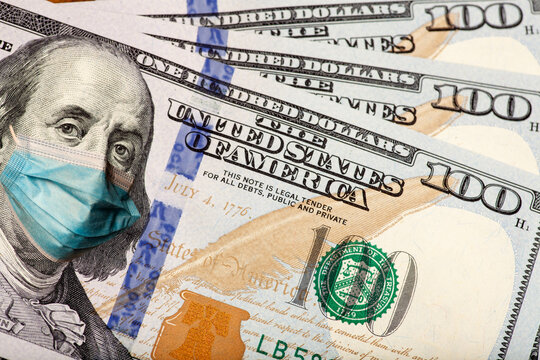 The New United States 100 Dollar Bill With A Medical Face Mask. Coronavirus Covid 19 Concept