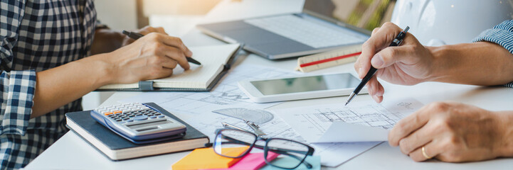 engineer with architect equipment discussing over blueprint 