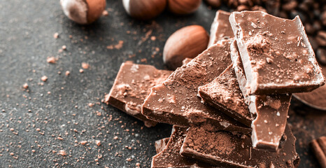 Chocolate and nuts on a black table with a worn surface