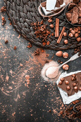 chocolate, cocoa and various sweet spices on black table