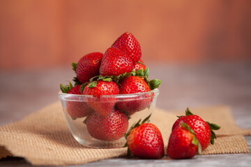 Strawberries are placed on a clear cup.

