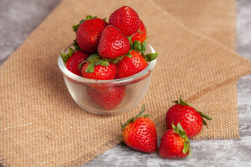 Strawberries are placed on a clear cup.
