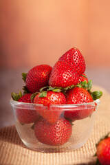 Strawberries are placed on a clear cup.
