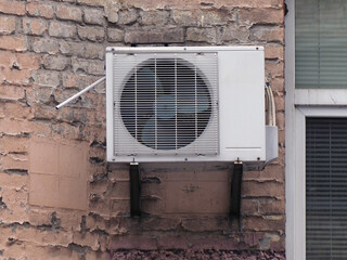 old outdoor air conditioning unit on the facade of the house
