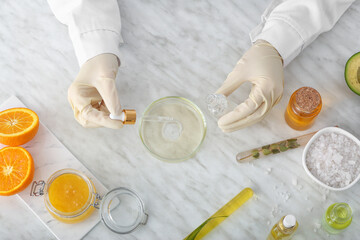 Beautician preparing natural cosmetic in laboratory, top view