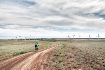 Fototapeta na wymiar Man ride bicycle to the wind turbine farm
