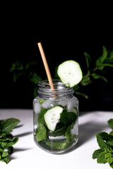 Mojito with cucumber and mint on black background