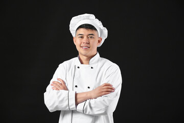 Handsome Asian chef on dark background