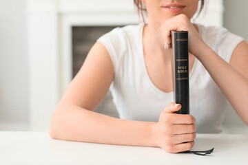 Young woman with Bible at home