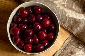 cherries in a bowl on a wooden table