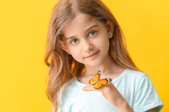 Cute little girl with butterfly on color background
