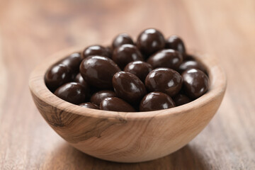 Chocolate drage with almond nuts in olive wood bowl