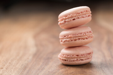 Tender pink color macarons on wood background with copy space