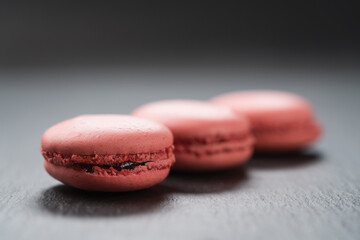 Obraz na płótnie Canvas Vivid pink color macarons on slate background closeup
