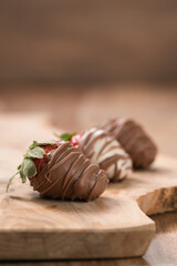 Chocolate covered fresh strawberry on wood background