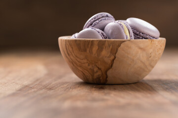 Blueberry macarons in olive wood bowl with copy space