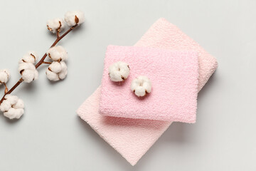 Cotton flowers and soft towels on grey background