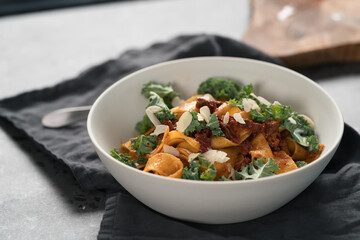 fettuccine pasta with sun-dried tomatoes, almond flakes and kale leaves