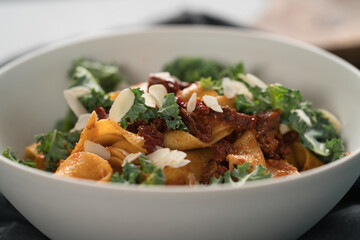 fettuccine pasta with sun-dried tomatoes, almond flakes and kale leaves