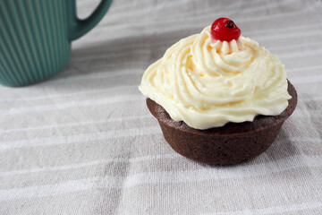 gluten free with rice and corn flour chocolate cupcake with cream cheese on a white table with a blue mug in the background