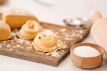 Raw pasta with flour on table