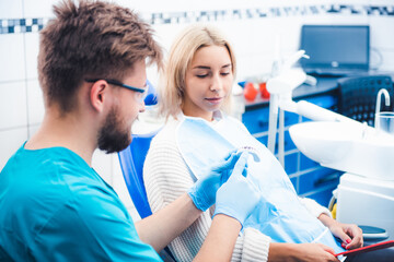 Dentist showing patient teeth model