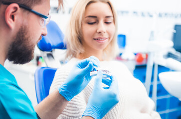 Dentist showing patient teeth model with kappa