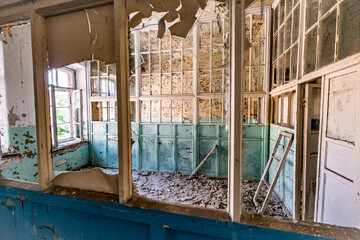 abandoned hospital light-blue colored room with lot of windows