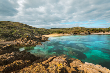 Tamarells beach in a sunny and cloudy day, abandoned paradise in Menorca, a Spanish Mediterranean island, after the covid 19 coronavirus crisis
