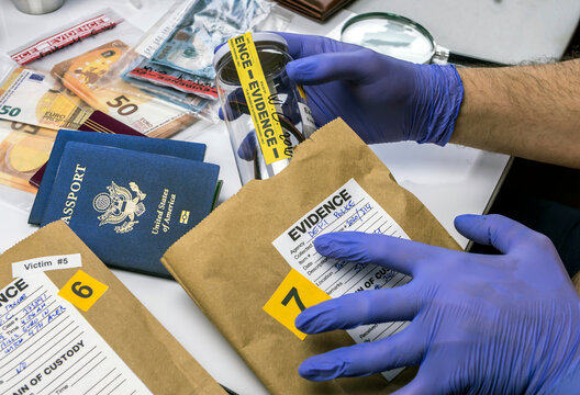 Expert police officer examining American passport of a evidence bag in laboratory of criminology, conceptual image