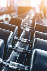row of dumbbells in modern gym, close up