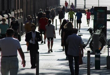 Personas a contraluz paseando por una calle