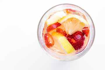 A refreshing summer drink made from soda and fruit. strawberries, lemon, apple. fruit in a glass, flying spray. healthy eating. quenching thirst