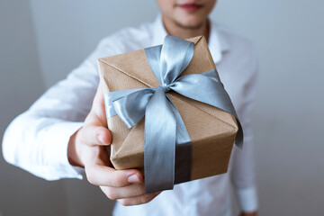 a gift in craft packaging and tools in the hands, give, a gift for the holiday