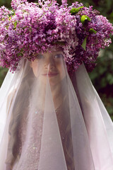 Caucasian girl child seven years old in a purple dress stands in nature
