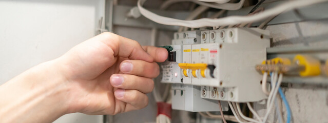 the professional electricity worker fixing the home lighting power problem, swithing the power panel