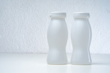 Packaging concept. Two white plastic bottles are on the table. Eco-friendly packaging. Biodegradable material. Concern for the environment. Ergonomic packaging.