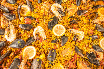 Plat de paella typique d'Espagne avec fruits de mer, riz, safran, moules et citrons.