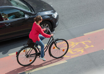 Woman riding a bicycle in a bike lane near traffic