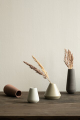 Group of ceramic vases of white and brown colors with dry plants inside