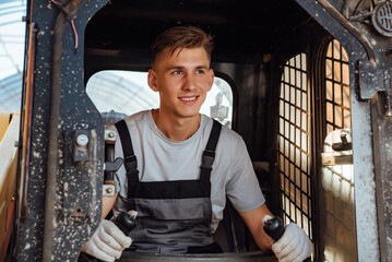 A man in overalls driving a tractor. Worker sitting on his tractor