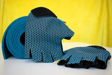 Blue rolled yoga mat and non-slip yoga gloves