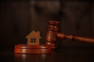 Mortgage concept. Wooden gavel and house at the desk