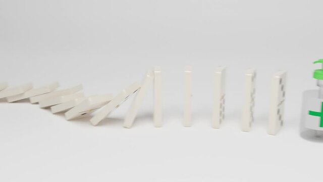 Gel alcohol bottle stops the dominoes from falling. New normal concept.