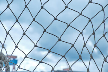 Fototapeta premium Ship rope network against a cloudy sky