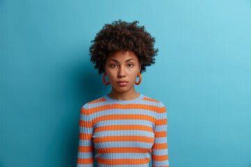 Portrait of serious girlfriend with calm confident attentive expression, wears casual striped...